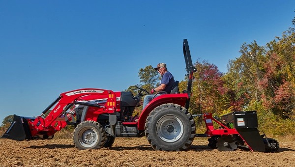 ide profile of a Massey Ferguson 1E Series compact tractor working a field with rear attachment – sold at USA Equipment, New Iberia, Louisiana.
