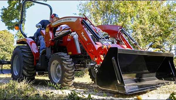 Operator using a Massey Ferguson 1E Series compact tractor with front-end loader for land work in South Louisiana – USA Equipment dealership.